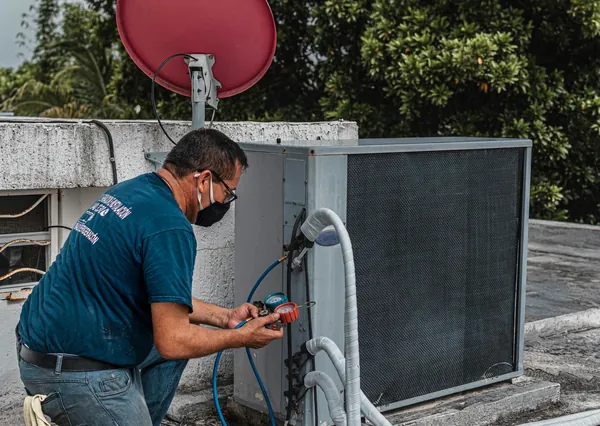 Técnico da Ice Mais medindo a pressão do gás na unidade externa